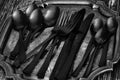 Set of black cutlery tableware on an antique silver tray. Royalty Free Stock Photo