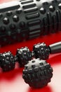 Set of Black lumpy foam massage roller, body roller, rubber ball on red background Royalty Free Stock Photo