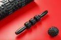 Set of Black lumpy foam massage roller, body roller, rubber ball on red background Royalty Free Stock Photo
