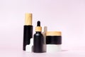 Set of black matte glass cosmetics bottles with bamboo lids on the white podium. Mockup background with cocncrete geometric Royalty Free Stock Photo