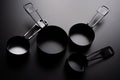 A set of black measuring cup on black background