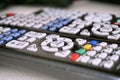 Set of black remote controls with colorful buttons on white surface as a symbol of home entertainment when watching televisi Royalty Free Stock Photo