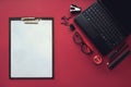 Set of black stationery elements with Plastic tablet and white sheet of paper on the red Background. Top View. Concept of new Royalty Free Stock Photo