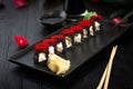 set of black sushi rolls on a black plate on a black wooden background Royalty Free Stock Photo