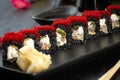 Set of black sushi rolls on a black plate on a black wooden background Royalty Free Stock Photo