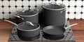 Set of black various sizes cooking pots and frying pan on electric stove, kitchen counter top. 3d illustration Royalty Free Stock Photo