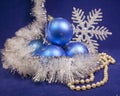 Set blue beautiful glass New Year`s balls, brilliant tinsel, and a pearl beads on a blue background - New Year`s composition, a c Royalty Free Stock Photo