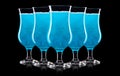 Set of blue curacao cocktails in hurricane glass isolated on black background Royalty Free Stock Photo