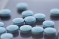 A set of blue pills on the table, close-up, shadow