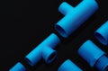 Set of blue PVC pipe fittings isolated on dark background. Blue plastic water pipe. PVC accessories for plumbing. Plumber Royalty Free Stock Photo