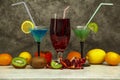 Set of blue red green cocktails in martini glasses with ice and fresh fruit kiwi pomegranate lin on a gray background. Set of cock Royalty Free Stock Photo