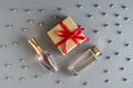 a set of bottles of women\'s perfume and a gift in craft packaging with a red satin ribbon on a gray background Royalty Free Stock Photo