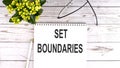 SET BOUNDARIES text concept write on notebook on wooden background