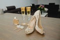 Set bride\'s accessories: perfume bottle, earrings, two glasses of champagne and women\'s shoes. Soft focus Royalty Free Stock Photo