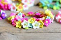 Set of bright bracelets on old wooden background. Bracelets made of colorful plastic flowers, leaves and beads. Accessories Royalty Free Stock Photo