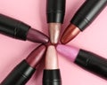 Set of bright lipsticks in black tubes on pink background Royalty Free Stock Photo