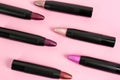 Set of bright lipsticks in black tubes on pink background Royalty Free Stock Photo