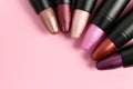 Set of bright lipsticks in black tubes on pink background, flat lay Royalty Free Stock Photo