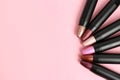 Set of bright lipsticks in black tubes on pink background, flat lay Royalty Free Stock Photo