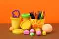 Set of bright play dough with mold and pencils on color background