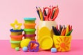 Set of bright play dough with tools and pencils on color background