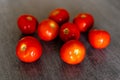 Set of bright red tomatoes on the wooden table of a kitchen Royalty Free Stock Photo