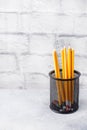 Set of bright simple pencils in a black stand on a gray table, copy space