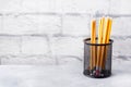 Set of bright simple pencils in a black stand on a gray table, copy space