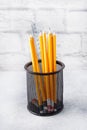 Set of bright simple pencils in a black stand on a gray table, copy space