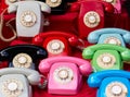 Set of brightly colored rotary phones arranged on a table