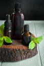 Set of brown bottles, sprigs of fresh mint on an old wooden background. Essential oil for aromatherapy