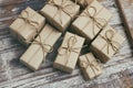 Set of brown gift boxes on wooden background. Wrapped in craft paper and tied by hemp cord. A lot of parcels. Royalty Free Stock Photo