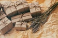 Set of brown gift boxes. Wrapped in craft paper and tied by hemp cord. Old paper background. Small lavender bouquet. Royalty Free Stock Photo