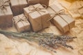 Set of brown gift boxes. Wrapped in craft paper and tied by hemp cord. Old paper background. Small lavender bouquet. Royalty Free Stock Photo