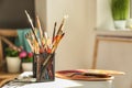 Set of brushes, spatula and palette on table in artist's workshop