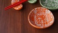 Set of ceramic dishes and red sushi sticks on wooden background Royalty Free Stock Photo