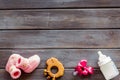 Cute baby clothes for girl, rattle, bottle and dummy on wooden background top view copyspace Royalty Free Stock Photo