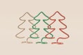 Set of Christmas trees stylish shapes made of red, beige, green metal wire. Concept illustration pine on a light background, Royalty Free Stock Photo