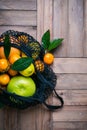 Set of citrus fruits in textile bag on old wooden table. Healthy food and zero waste concept Royalty Free Stock Photo