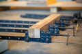Production process at carpentry workshop, clamps for compression and wooden block laying on table. Royalty Free Stock Photo