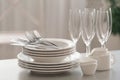 Set of clean dishware, cutlery and champagne glasses on table indoors Royalty Free Stock Photo