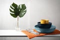 Set of clean dishware, cutlery and tropical leaves on white table Royalty Free Stock Photo