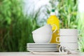Set of clean dishware and detergent on white table against blurred background, space for text Royalty Free Stock Photo