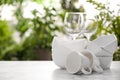 Set of clean dishware and wineglasses on white table against blurred background. Space for text Royalty Free Stock Photo