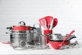 Set of clean kitchenware on white table against brick wall Royalty Free Stock Photo