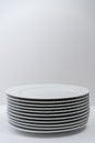 Set of clean stacked white plates on a white table. Copy space