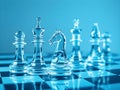 A set of clear glass chess pieces, including a knight and pawns, illuminated in soft blue light. The elegant design and Royalty Free Stock Photo