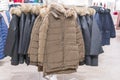 Set of clothes, coat on the rack clothing shop interior on background. Winter jackets in a store Royalty Free Stock Photo