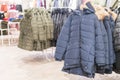 Set of clothes, coat on the rack clothing shop interior on background. Winter jackets in a store Royalty Free Stock Photo