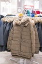 Set of clothes, coat on the rack clothing shop interior on background. Winter jackets in a store. vertical photo